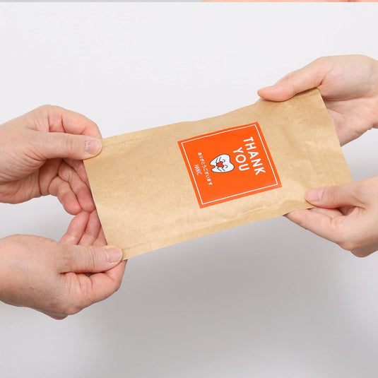 「ありがとうございます」のメッセージ付きギフト用ペーパー歯みがきを手渡しているイメージ